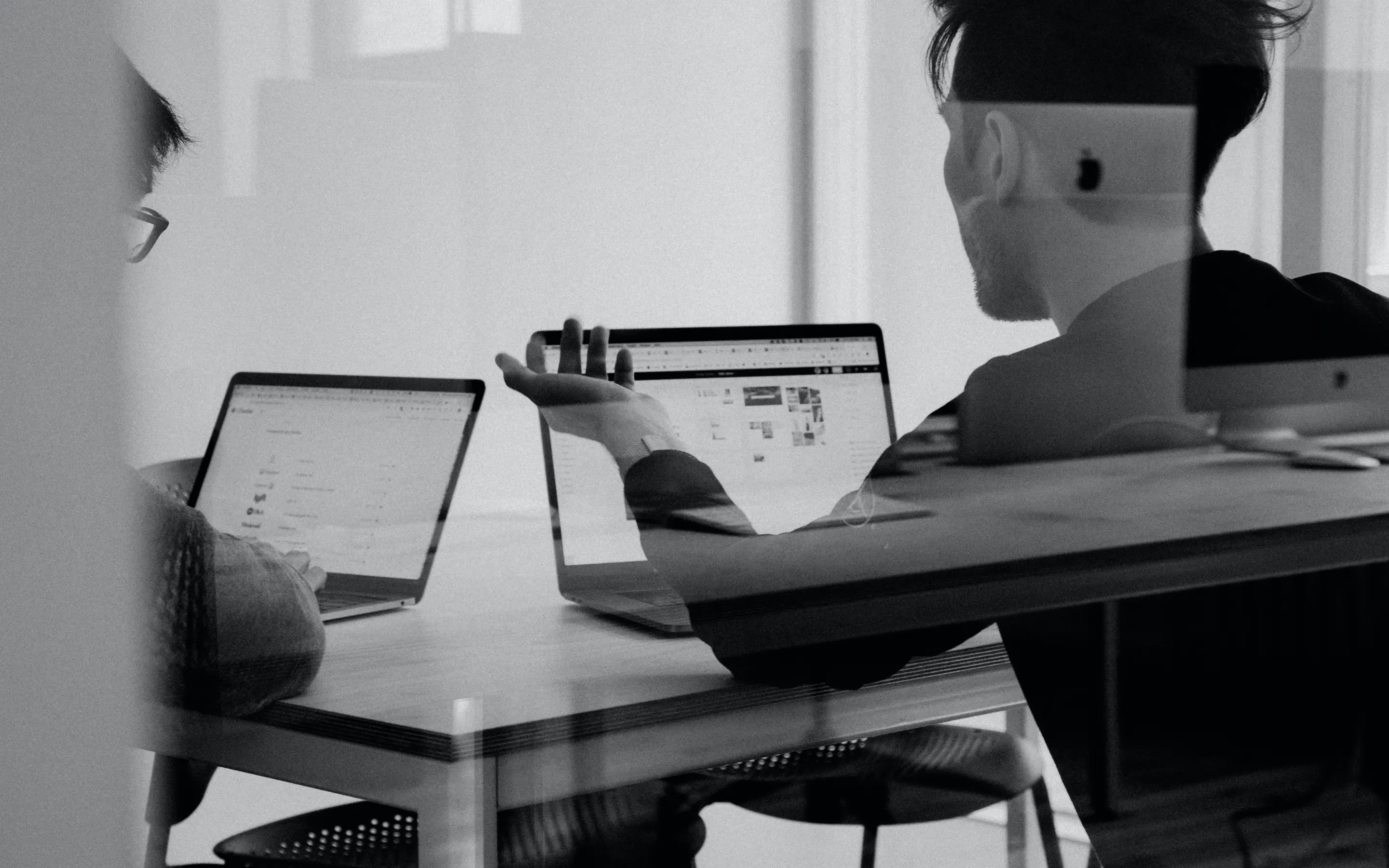 Reflection of man working on laptop